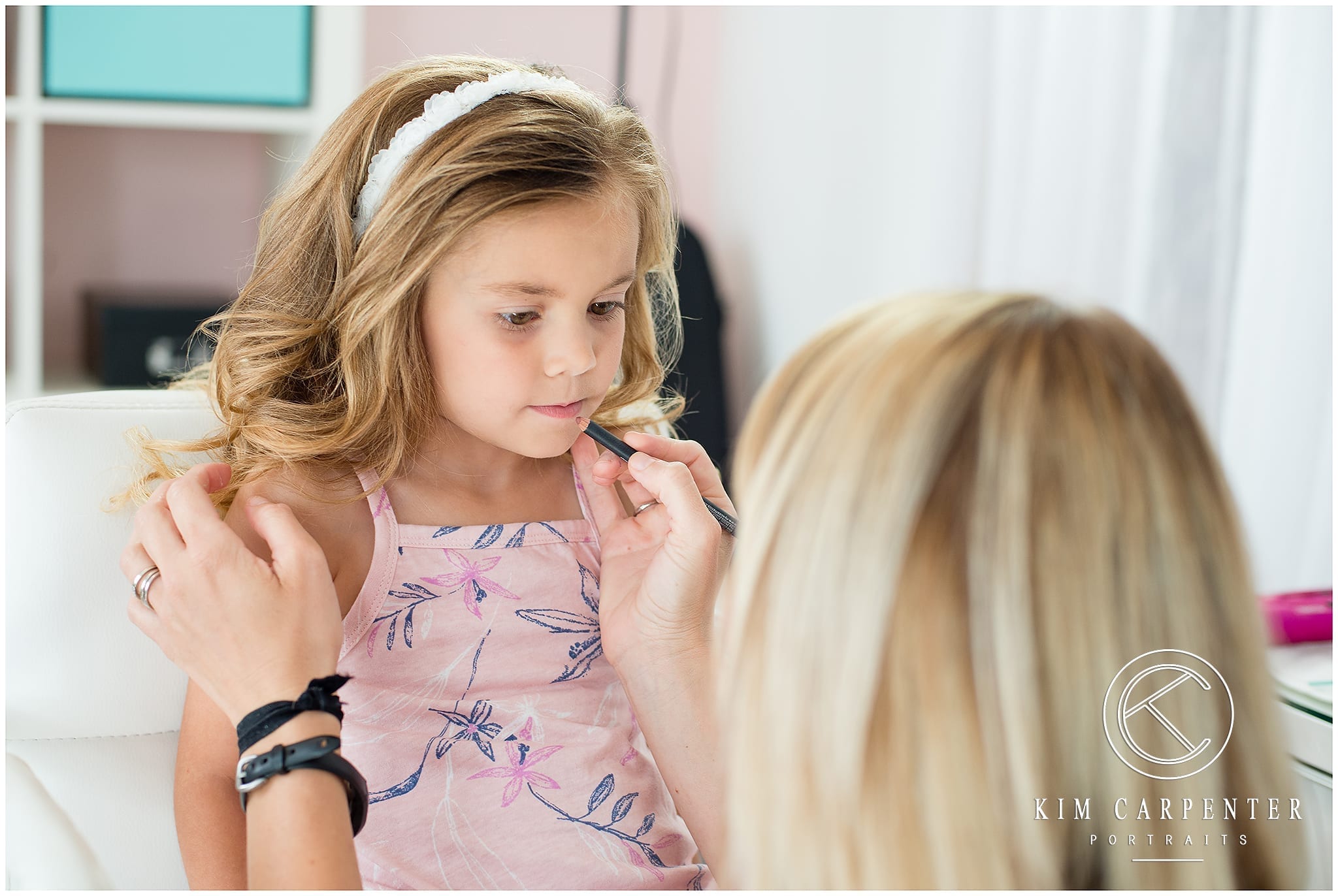 Picture of woman doing little girl's makeup