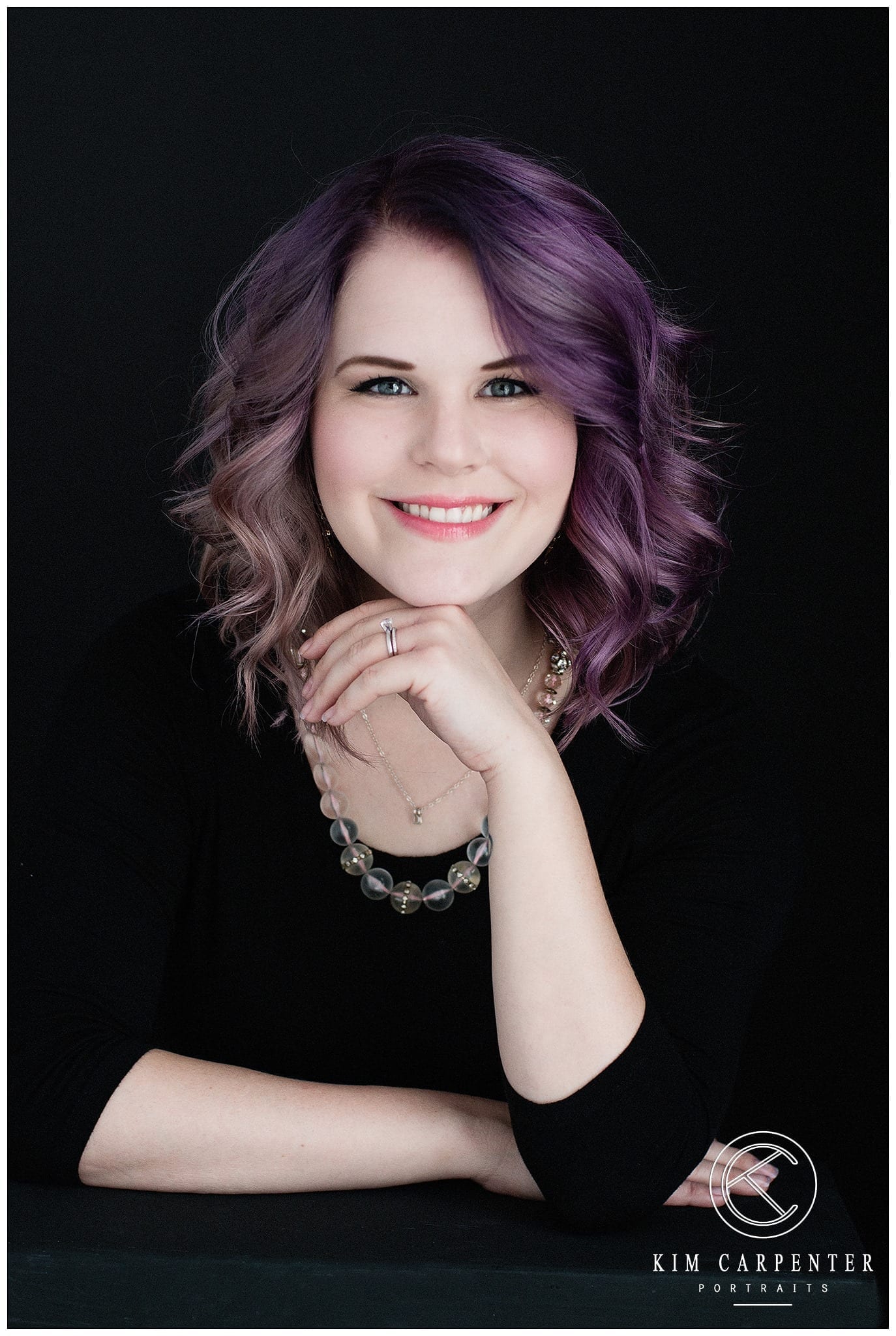 Woman with pastel purple hair posing for a professional headshots session.